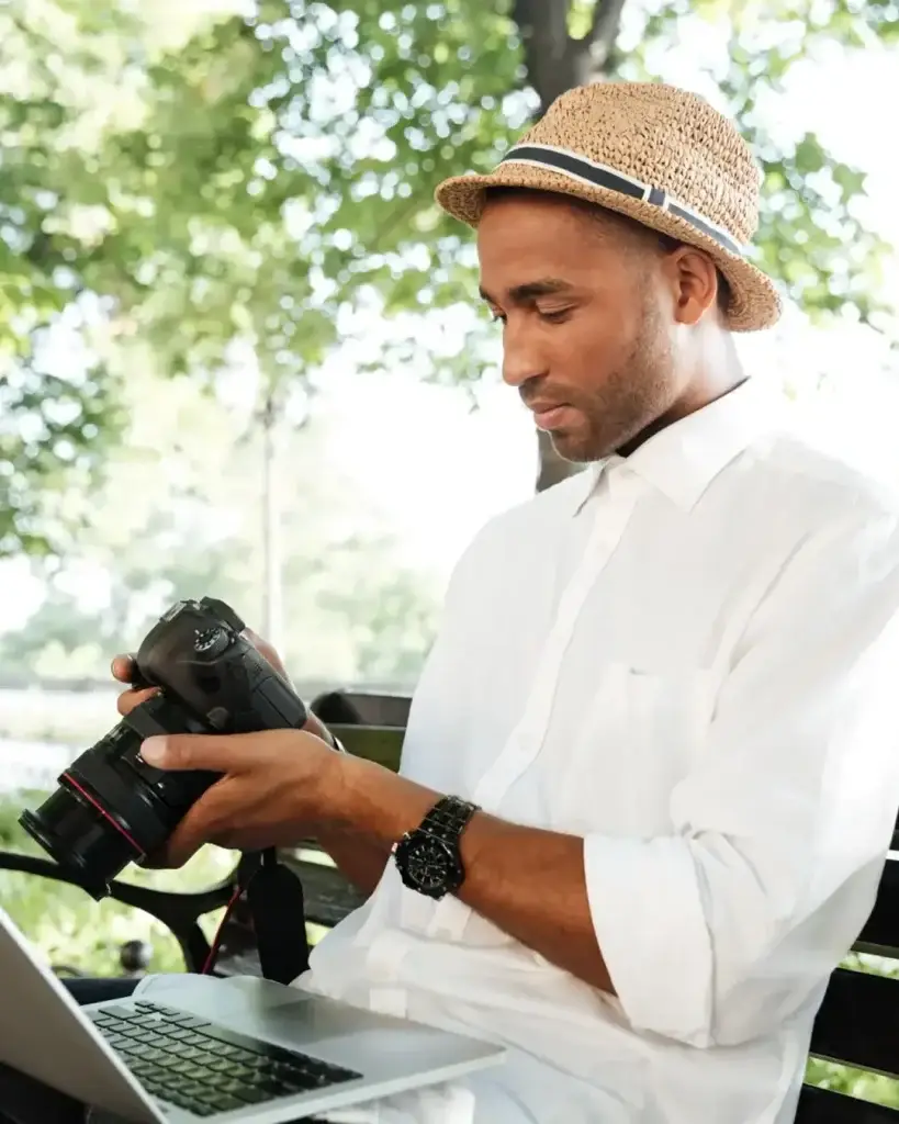 Content creator, wearing a hat, looking at his camera