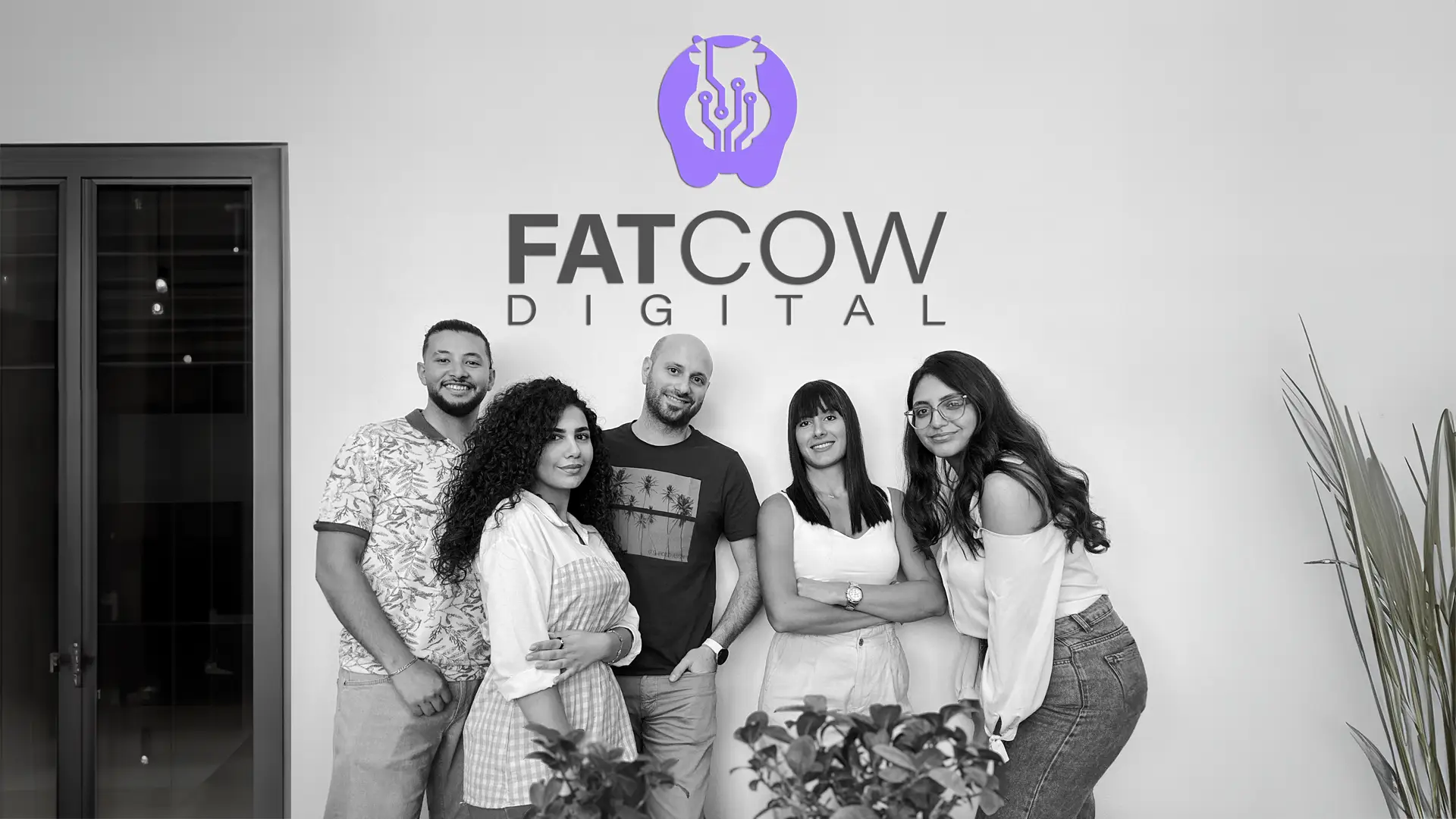 Original Team of Fatcow Digital with company logo on wall behind them - close up