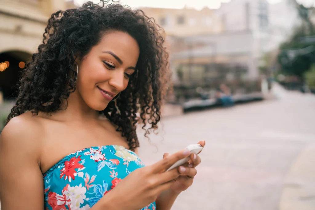 afro american latin woman using mobile phone responding to comments