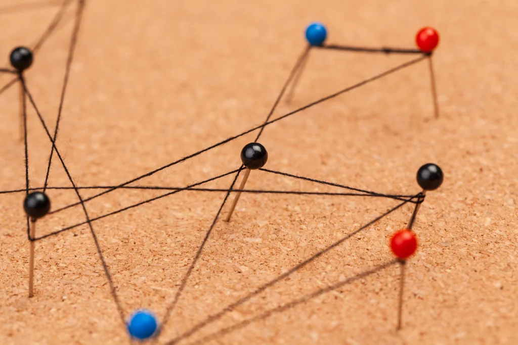 pins on a placed on a soft wood board tied together by a piece of string to portray the connectedness of social media marketing and SEO