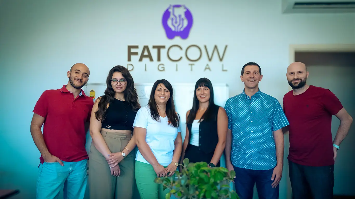 The Fatcow Digital digital marketing team standing in front of the logo with some of the agency's partners